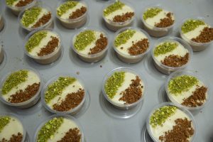 Multiple small containers of assida, topped with green and brown ground nuts