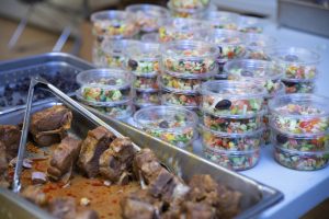 Cooked lamb chops and packages of salad for CVRAN's Tunisian feast.