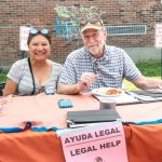 Two people behind a table labeled "Legal Help"