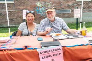 Two people behind a table labeled "Legal Help"