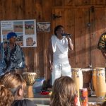 People drumming and someone singing into a microphone