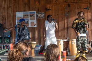 People drumming and someone singing into a microphone