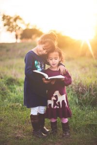 Two girls reading a book outside. Image: Ben White, Unsplash.com
