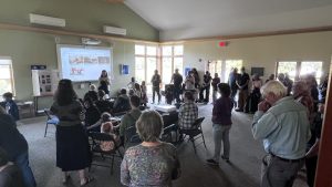 A gathering of people inside, watching a presentation. Image: A. Zenie