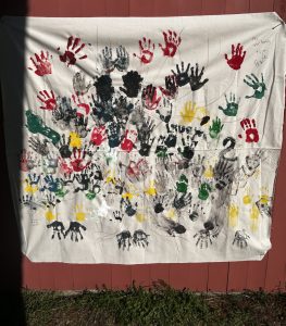 A mural of colorful handprints. Image: A. Zelie
